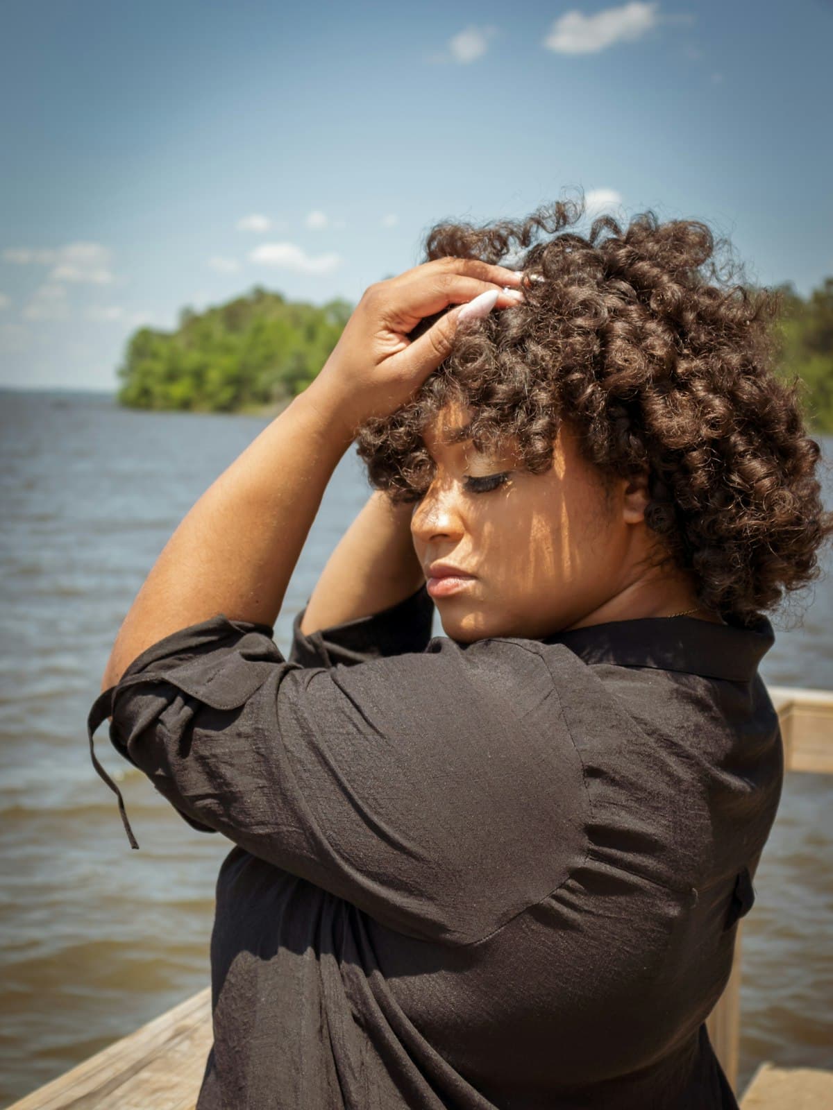 A woman with curly hair smiling outdoors